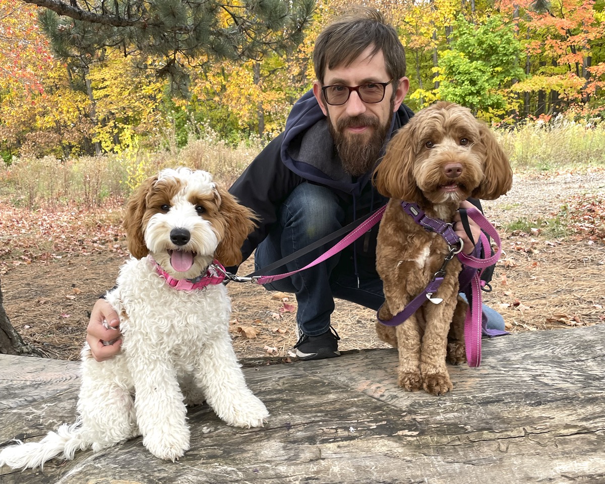 Andrew Judd outdoors in fall with his two dogs